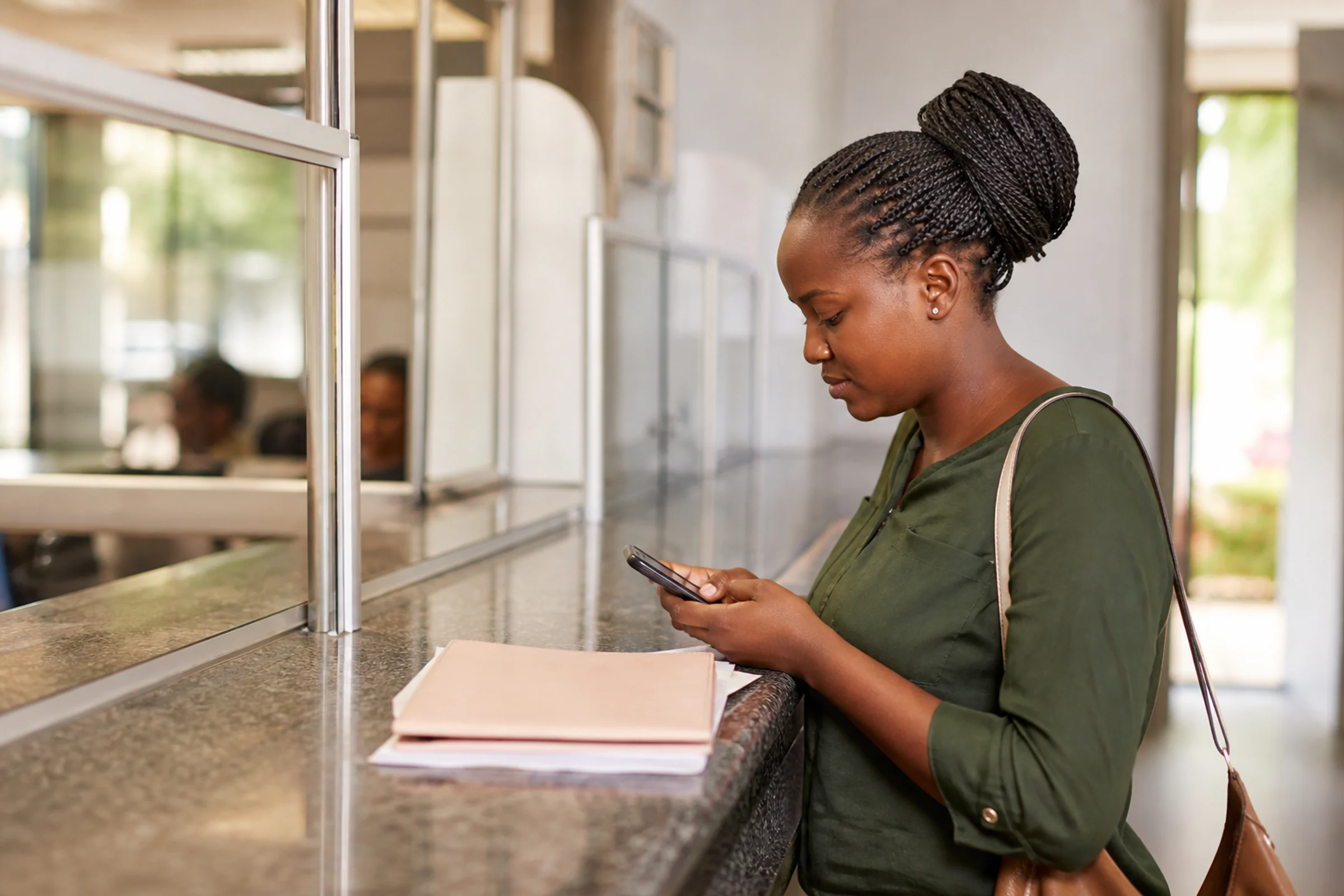A woman uses her phone at a service counter